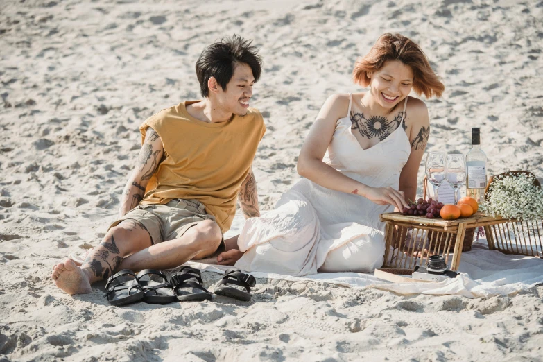 a woman sitting next to a man on the beach