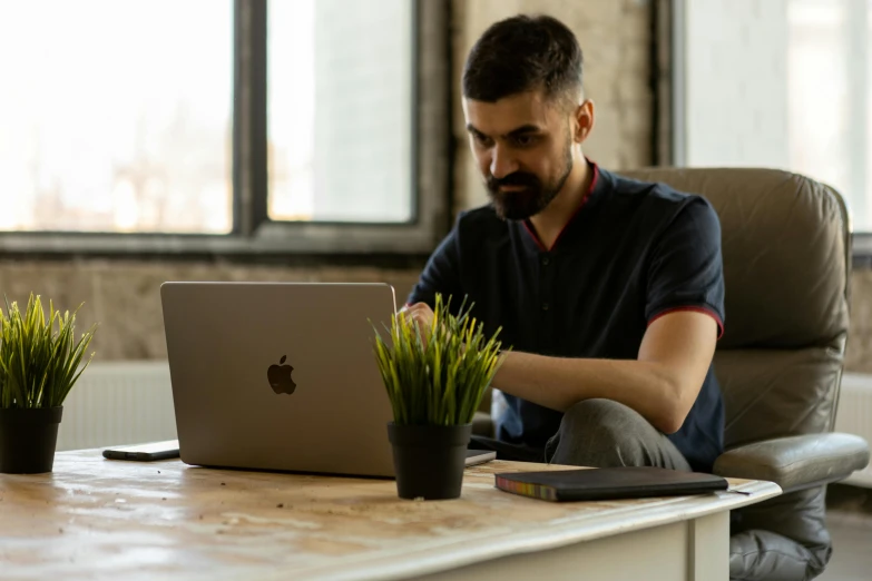 a man is typing on his apple laptop