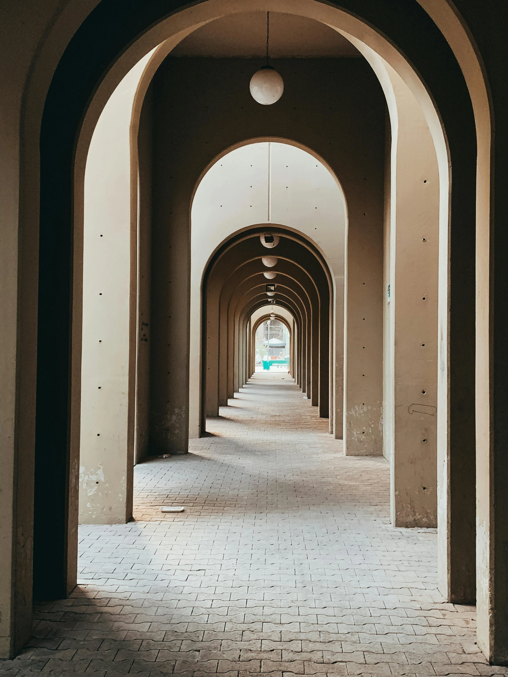 an empty hallway is lined with arches and brick