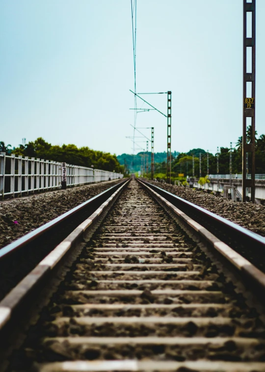 an empty railroad track leads away from the camera