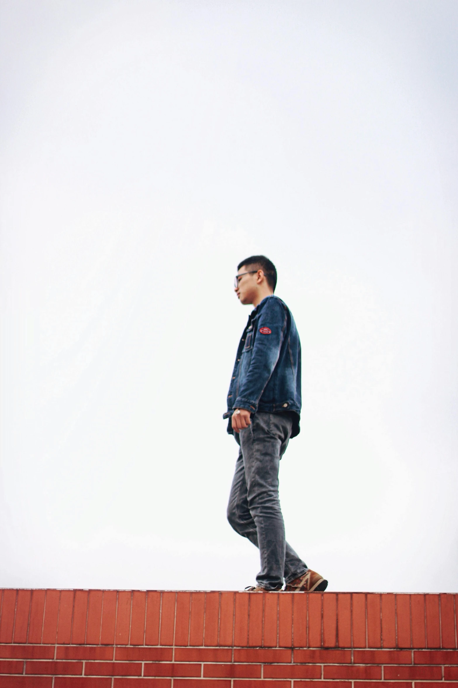 man standing on brick surface with a sky background