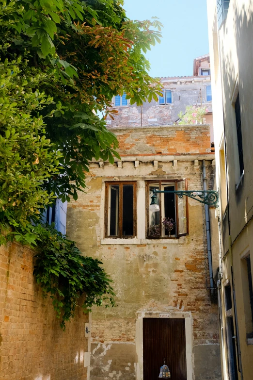 an old house with lots of windows and a tree on the outside