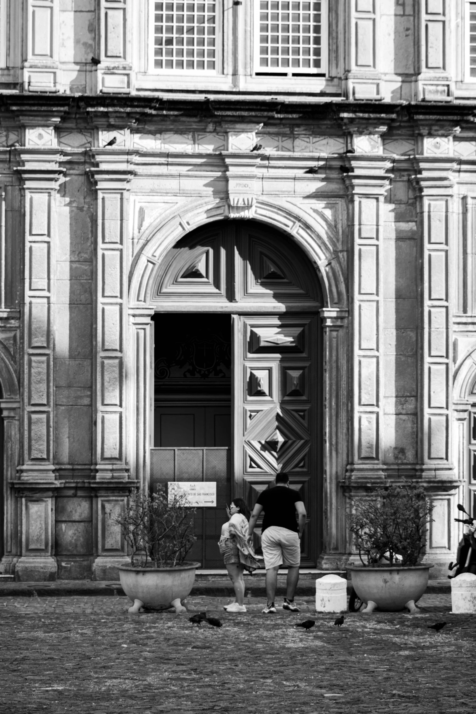 a black and white image of a group of people outside a building