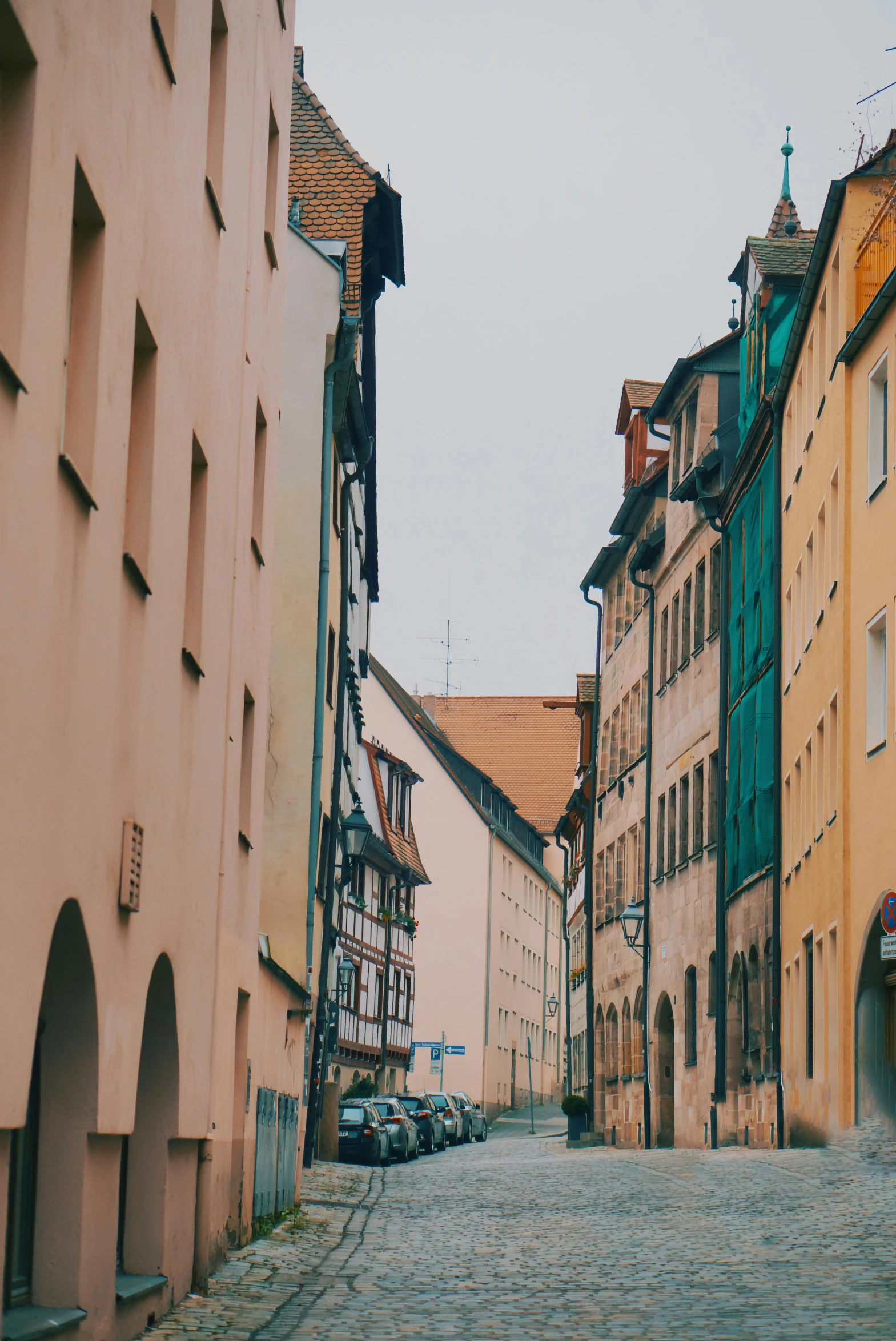 a narrow cobblestone street between buildings