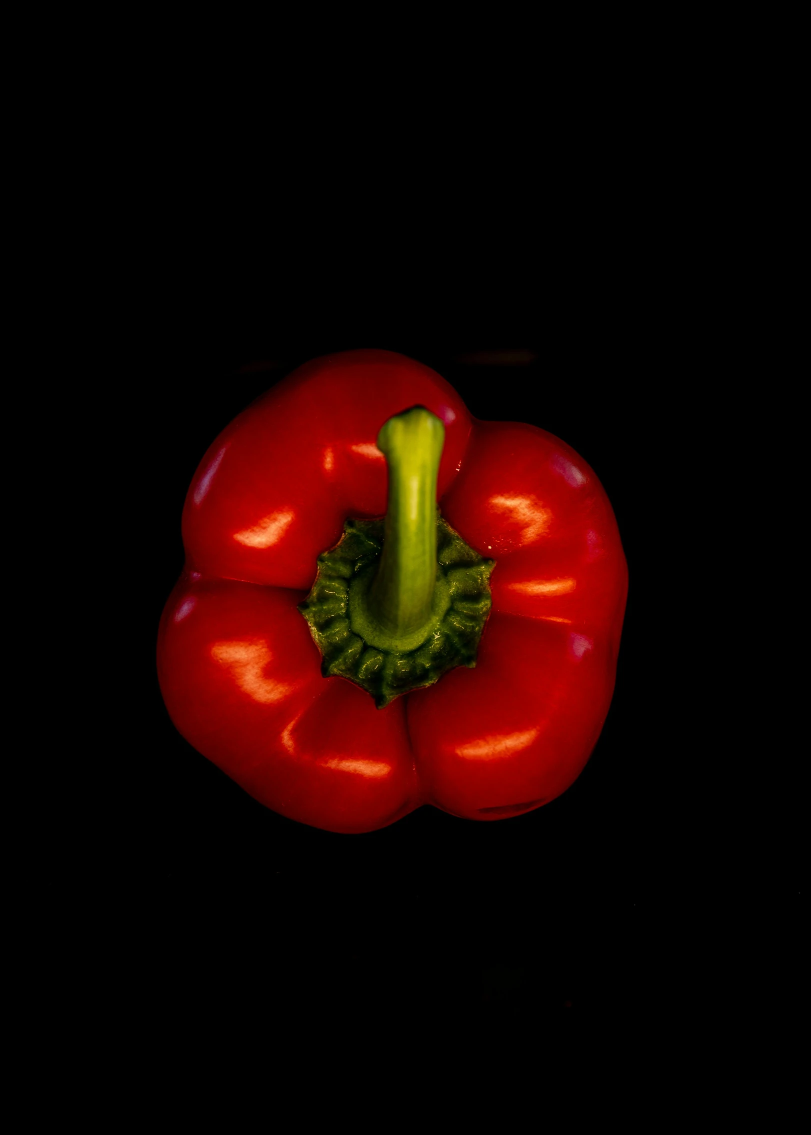 some red peppers are close together with black background