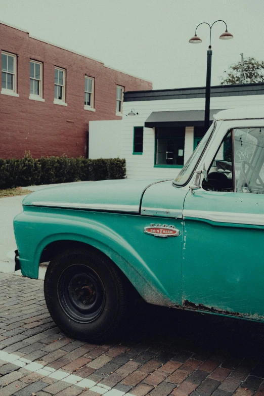 old blue pick up truck parked in a parking lot