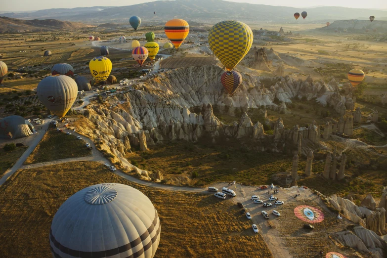 a group of  air balloons fly over a mountain valley