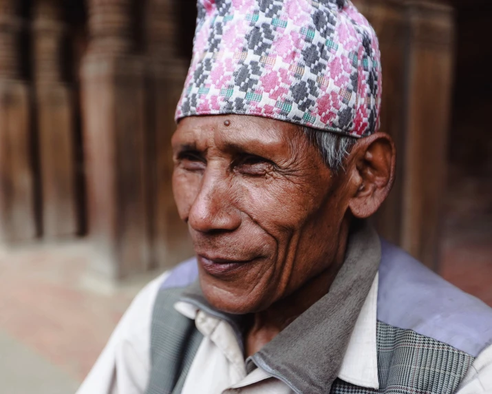 an old man with a large cap and overalls smiling