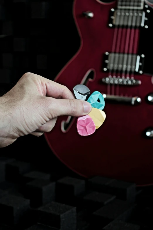 a person holds two pieces of colored paper over their fingers