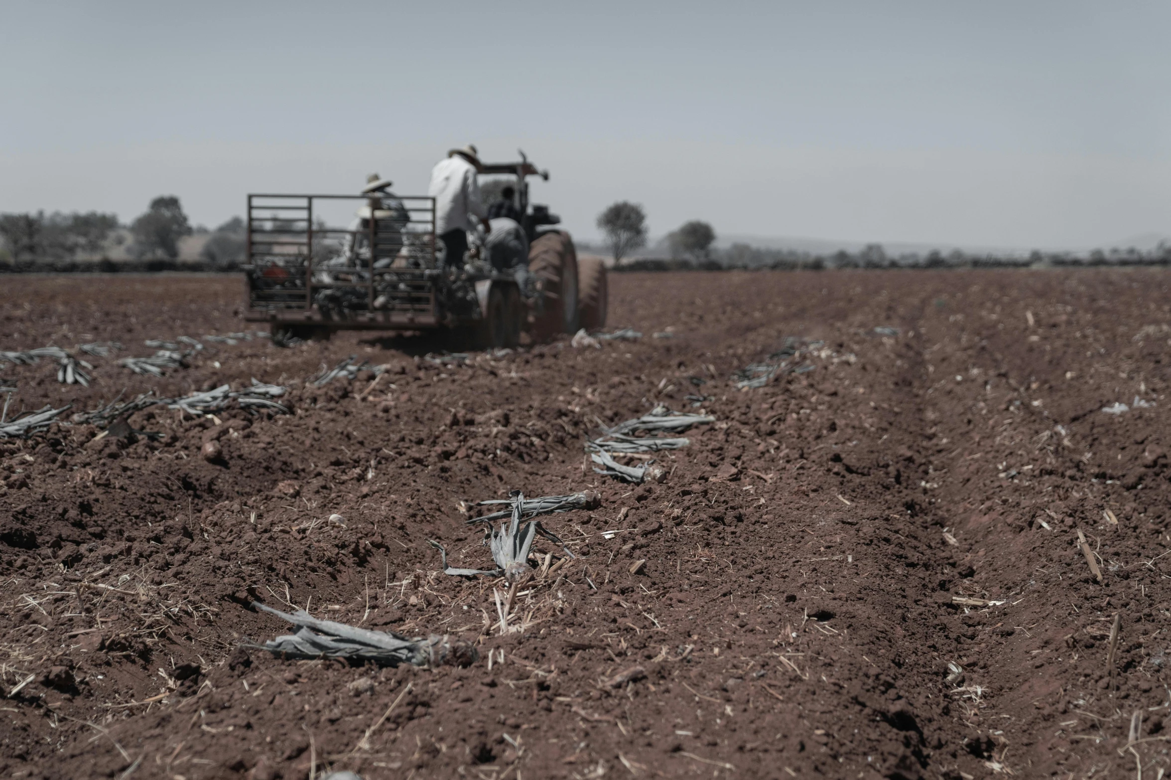 a tractor is driving across a plowed field