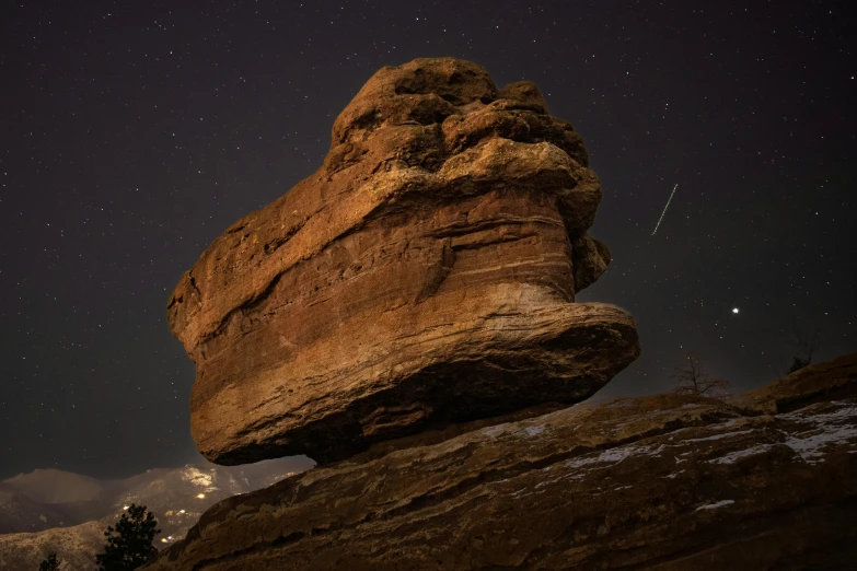 a rock formation with a star filled sky above it