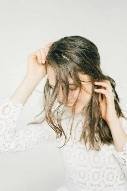 a woman wearing a sweater holding her hair