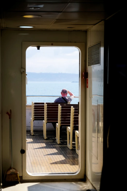 a man sitting on top of a bench near the ocean