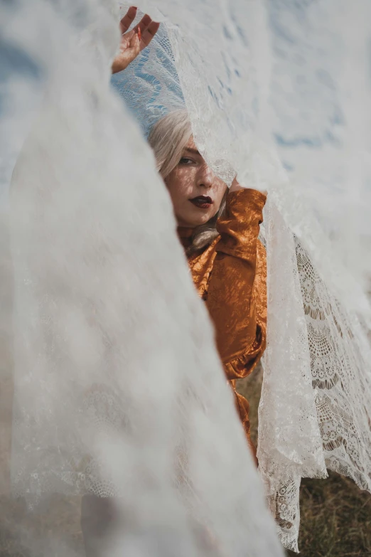 woman peeking out from an ice covered fence