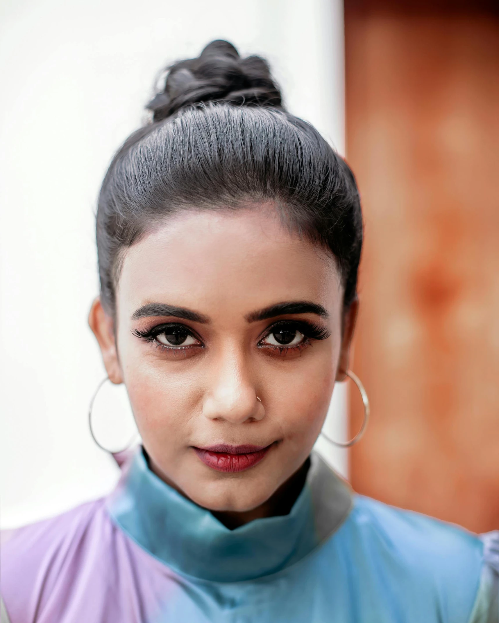 a woman with earrings wearing a blue outfit