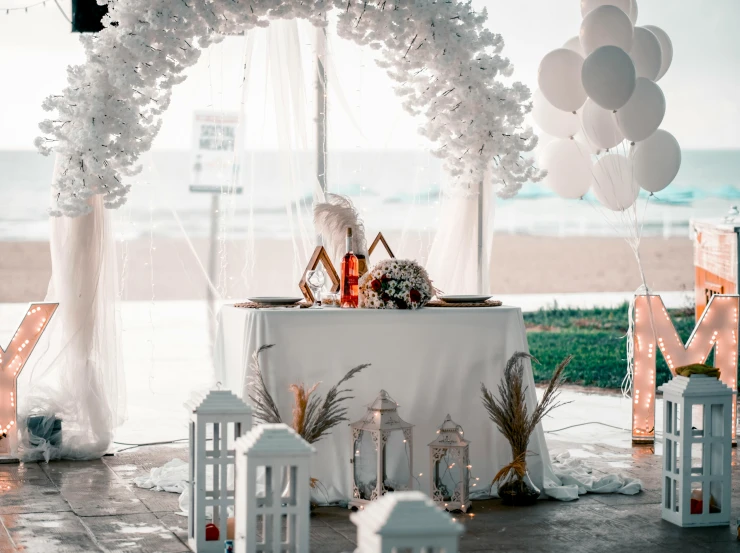 an outdoor wedding set up with balloons and lanterns