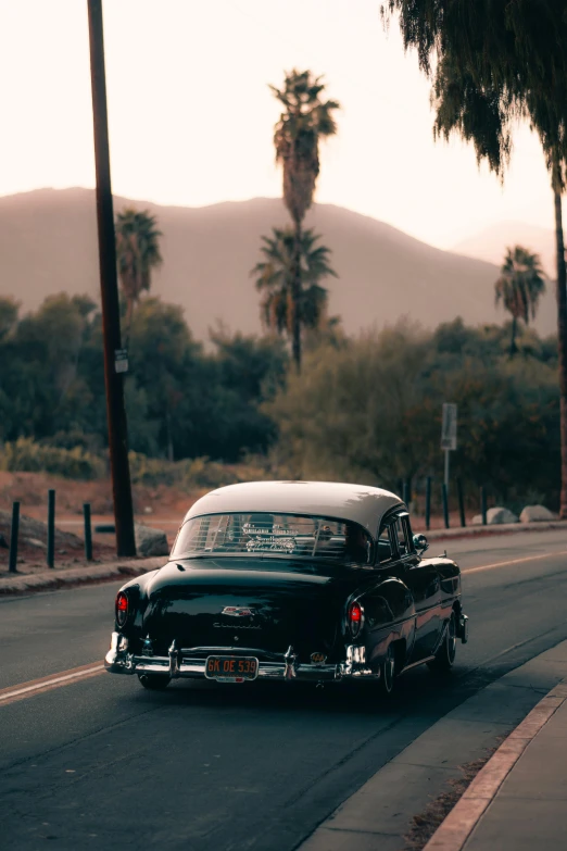 an old black car that is parked on the street