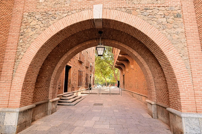 a sidewalk with stone steps between two arches