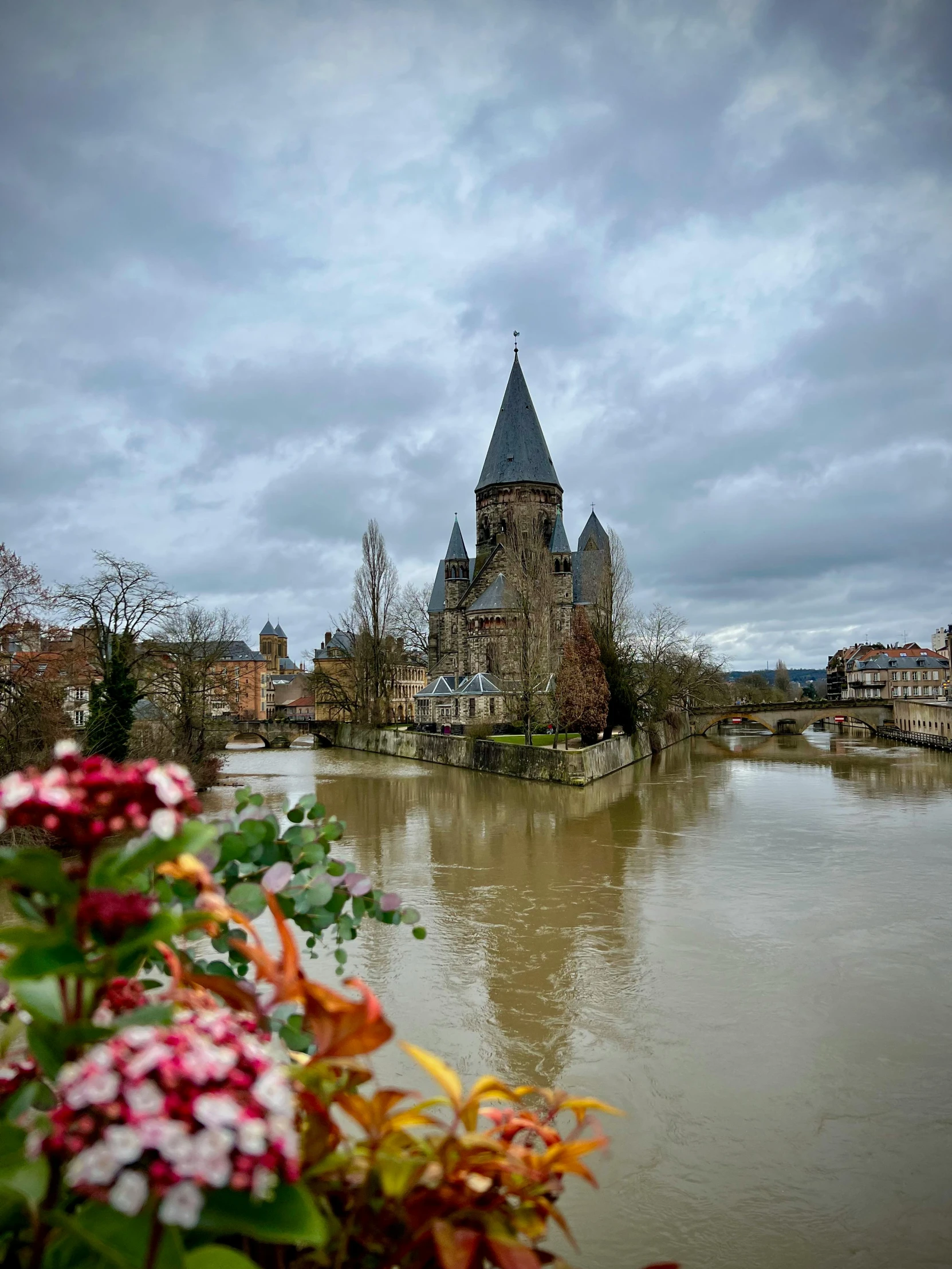 flowers in front of a church near the water