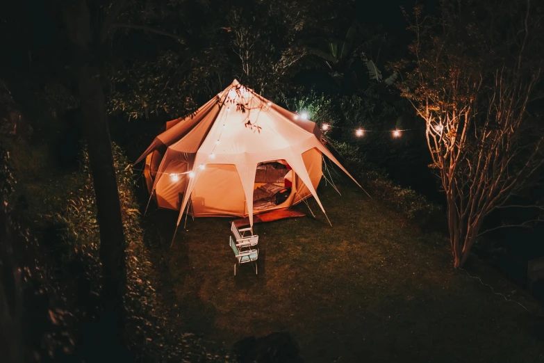 a tent set up on the grass with a laptop in it