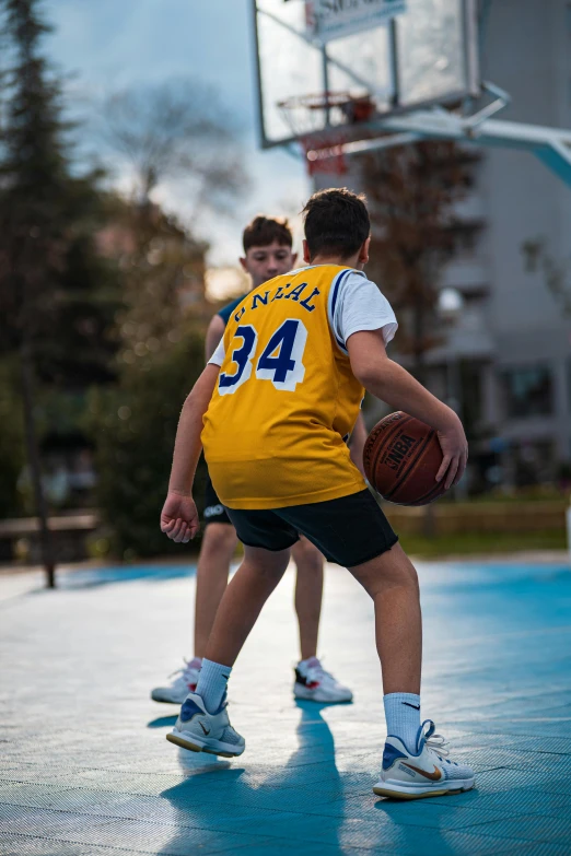 a couple of young men playing basketball on an indoor court