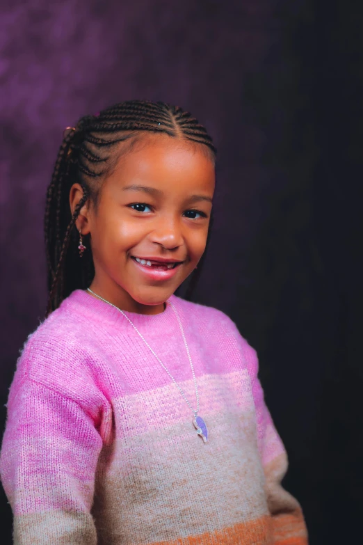 a girl in pink and orange sweater smiling