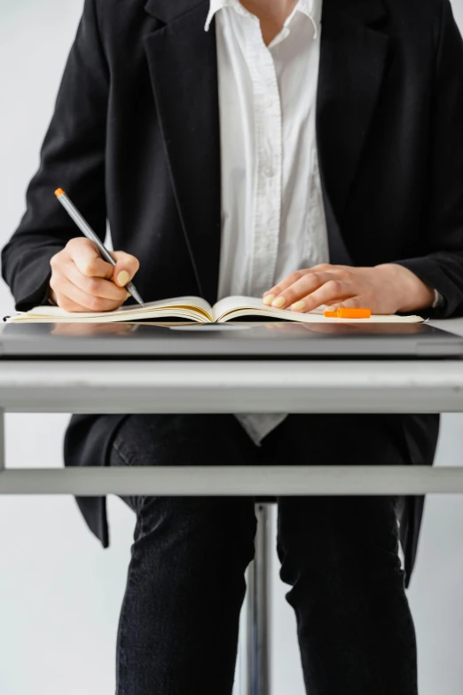 a person holding a pencil is in their lap with books on the table
