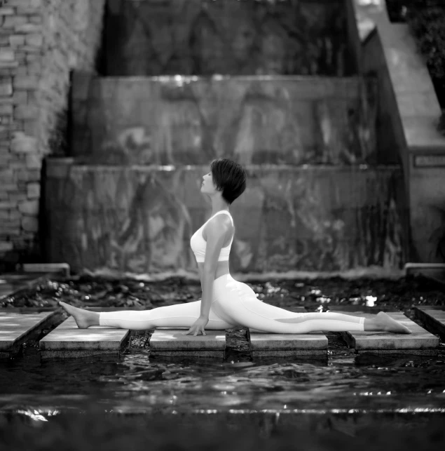 a woman sitting on a wooden platform in the water