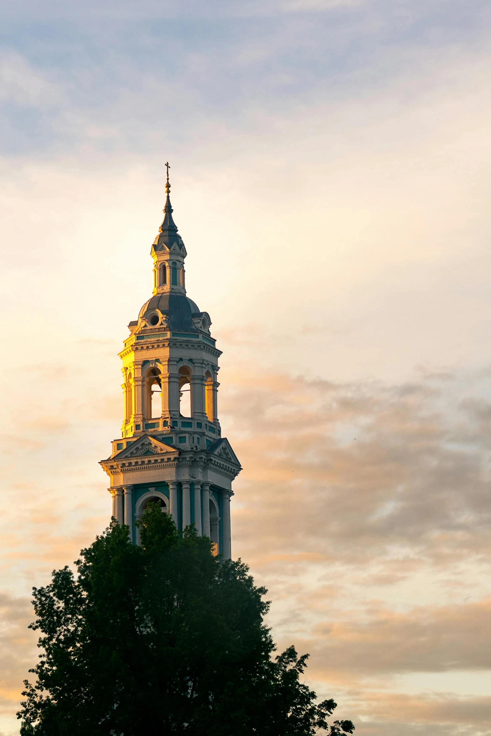 a clock tower against an orange and blue sky