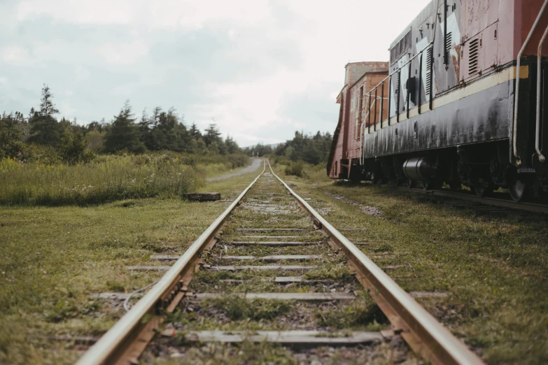 two train cars sit side by side on the train tracks