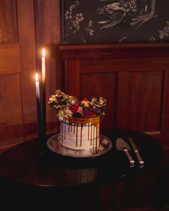 a chocolate and white cake with two candles sitting on a table