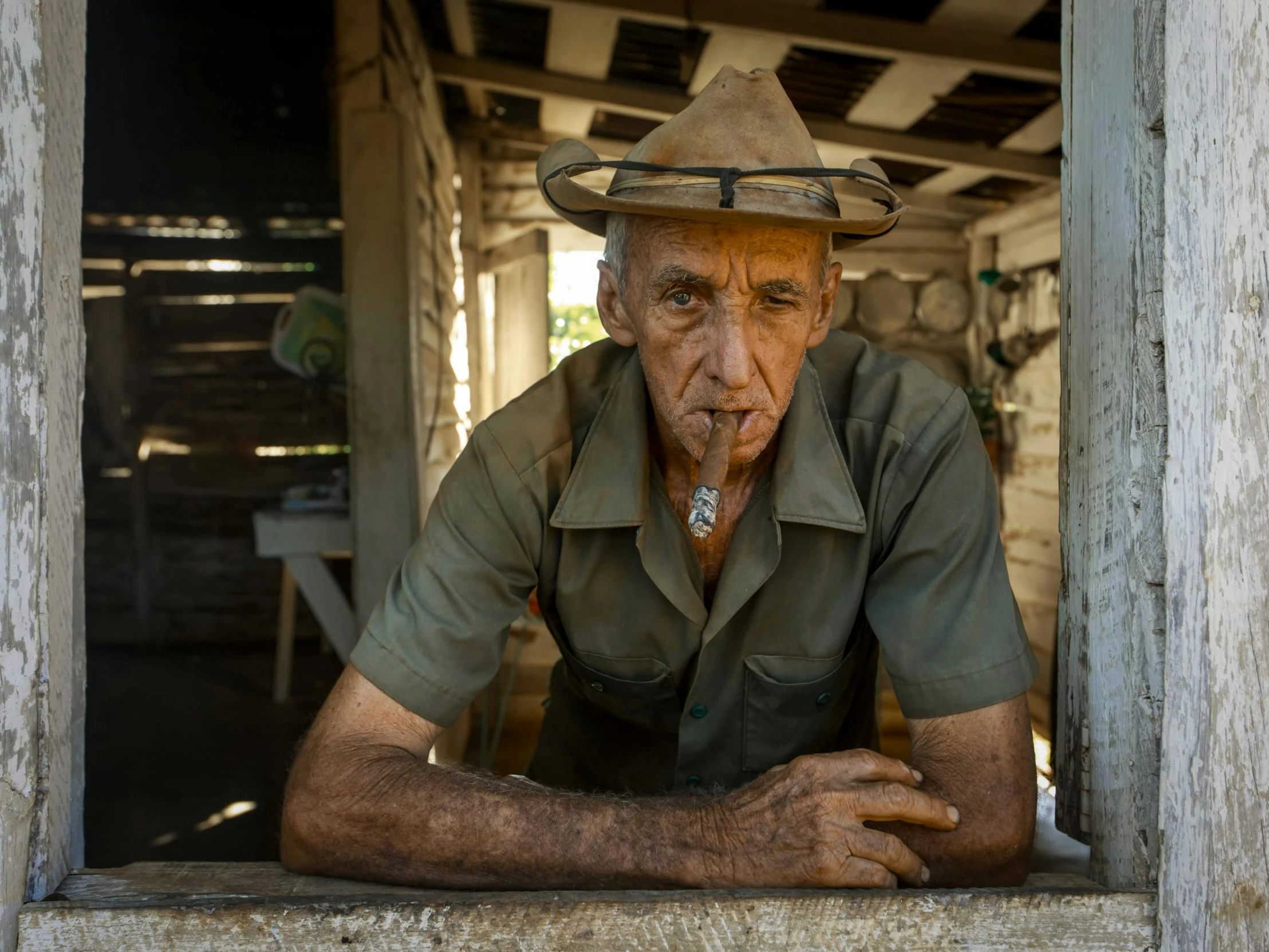 a older man sitting outside in a straw hat