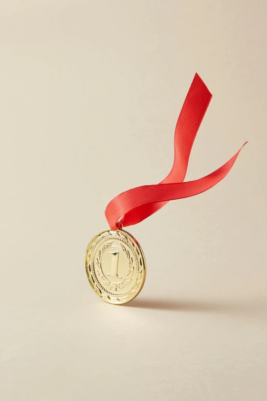 a single gold medal with a red ribbon around it