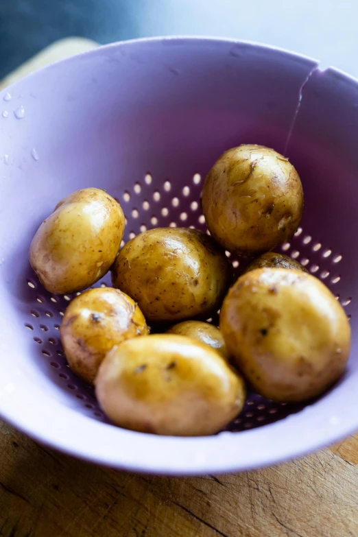 there is a bowl full of potatoes sitting on the table