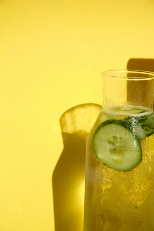 cucumber slices in a glass next to a bottle