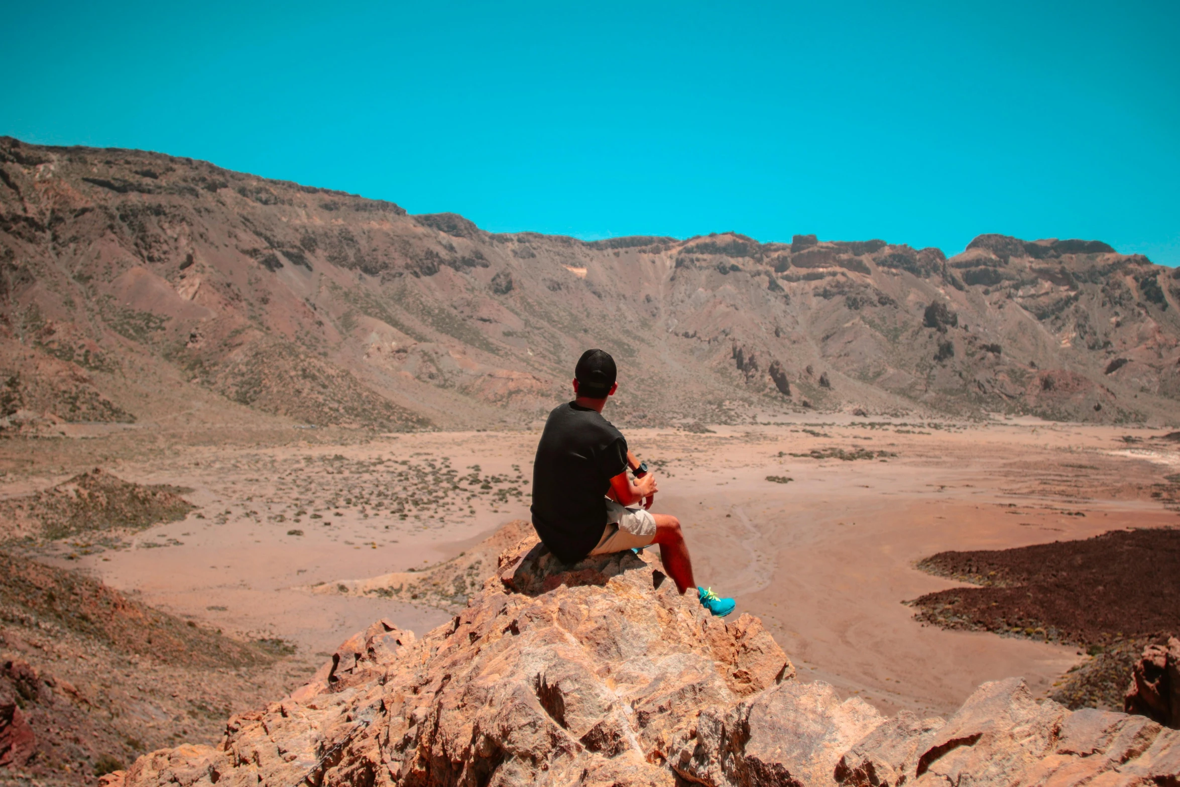 a person sitting on top of a large rock