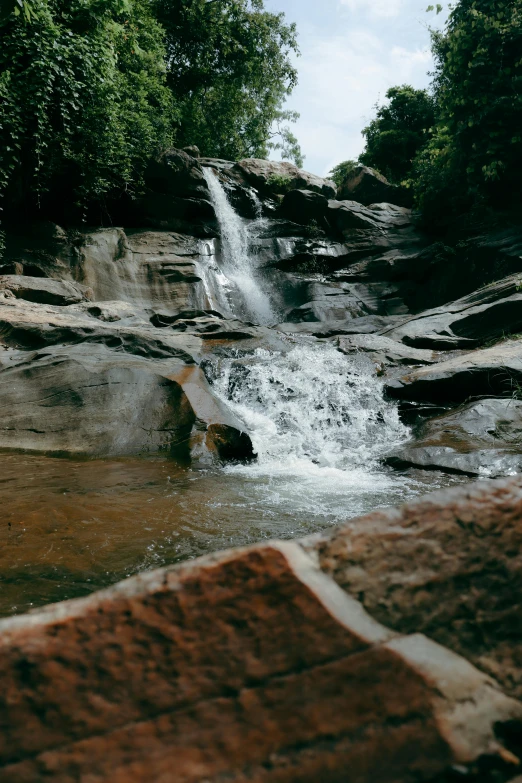 a waterfall is in the middle of a rocky field