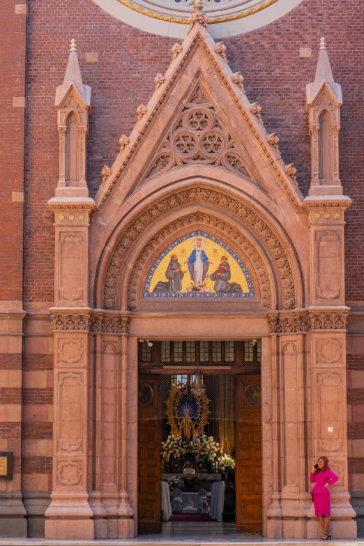 a woman stands in front of an ornate building