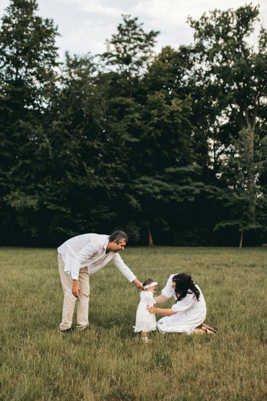 a father giving his daughter a high five while standing in a field