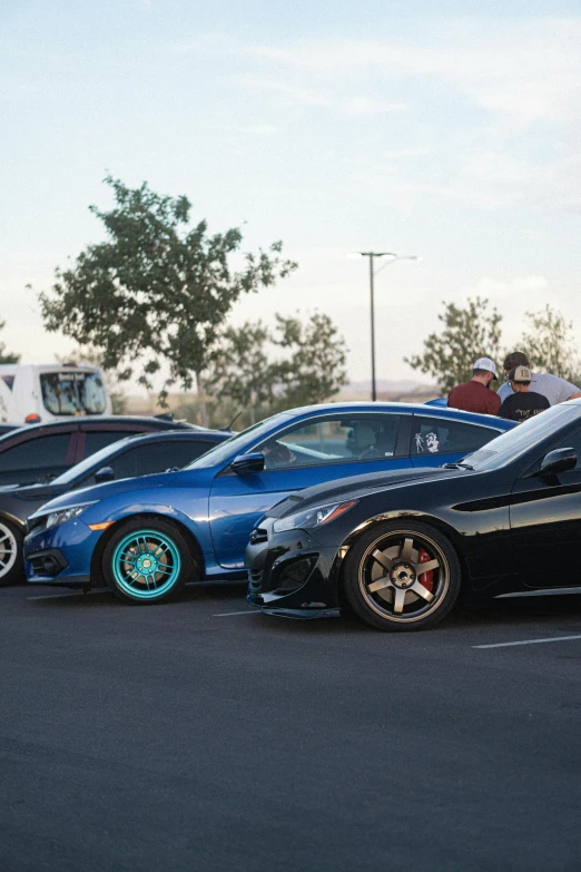 many cars in a parking lot with people watching