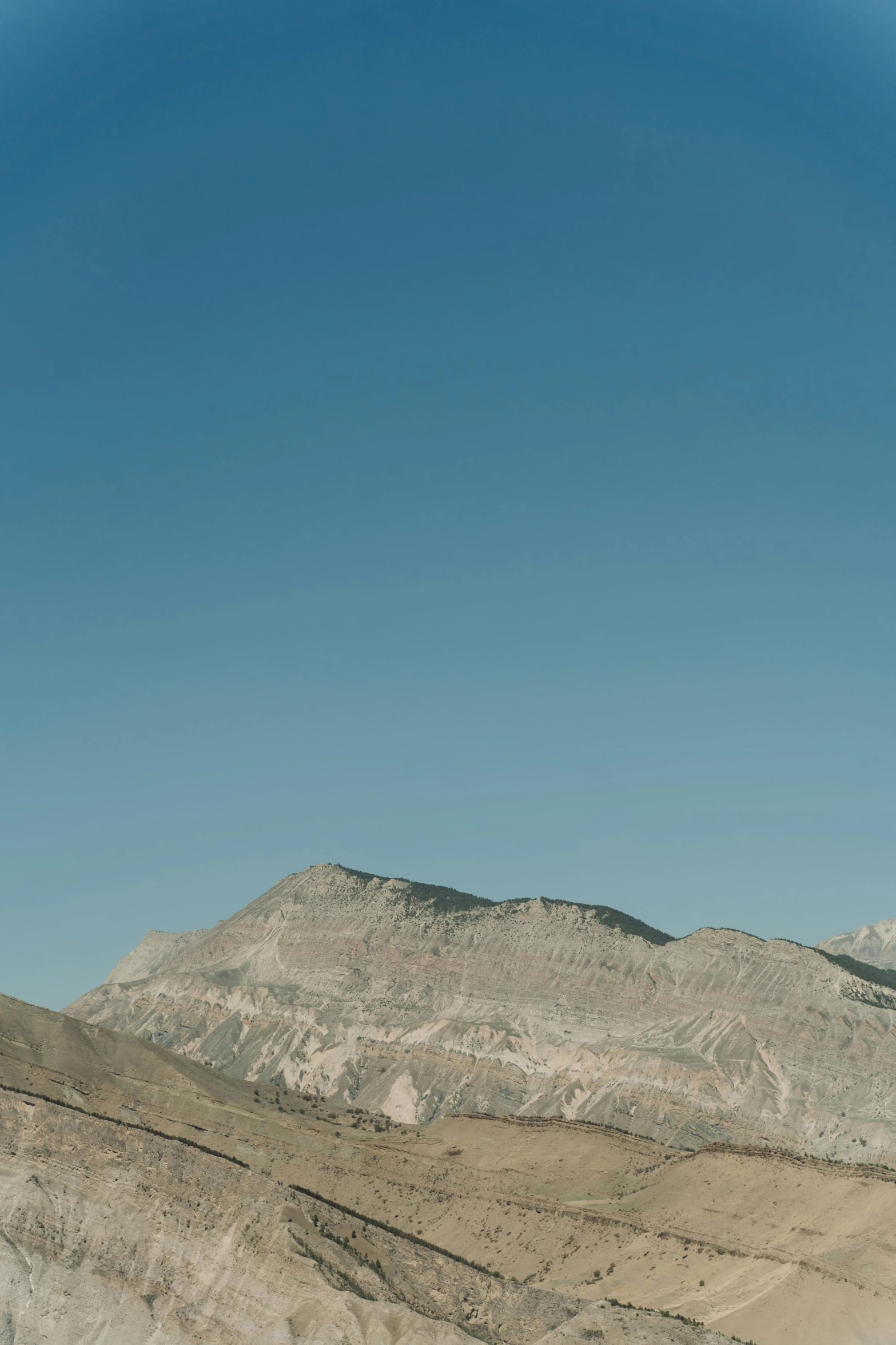 a plane in the sky over some hills