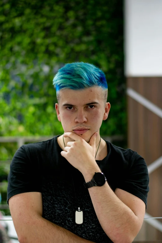 a man with green and blue hair in black shirt