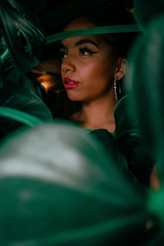 a woman wearing a green dress and gold earrings