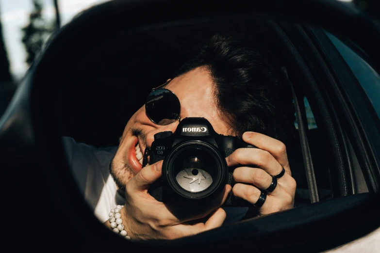 man taking picture of himself in side view mirror