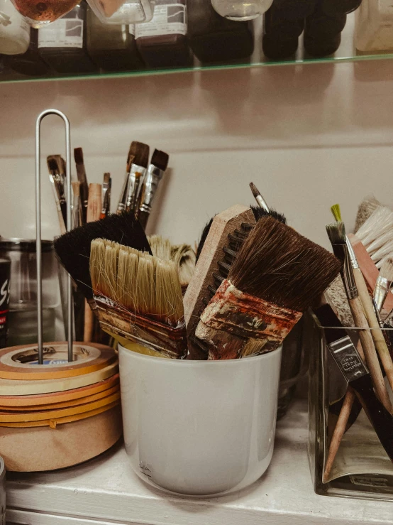 there is a paint bucket that has several different brushes inside