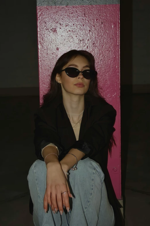a woman with sunglasses sitting on a floor