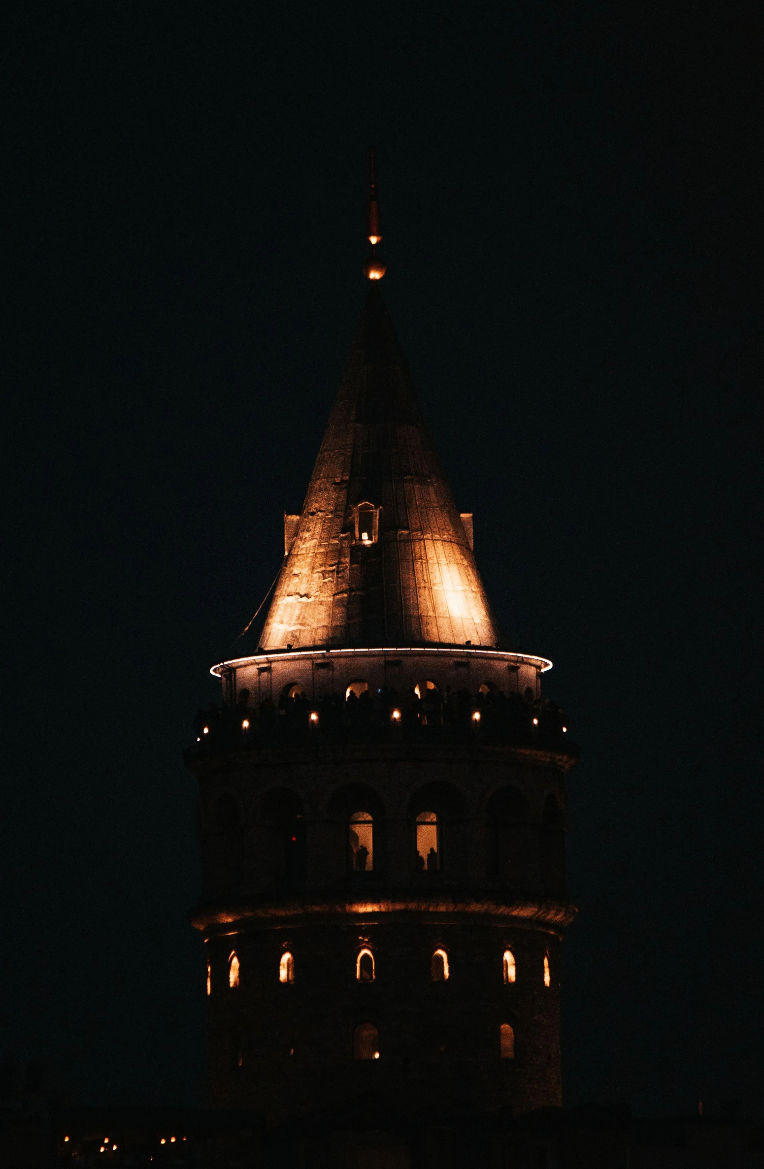 the illuminated view of a clock tower against a dark sky