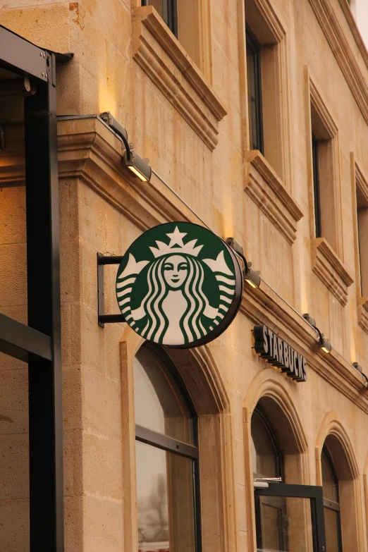 a starbucks sign in front of a large building