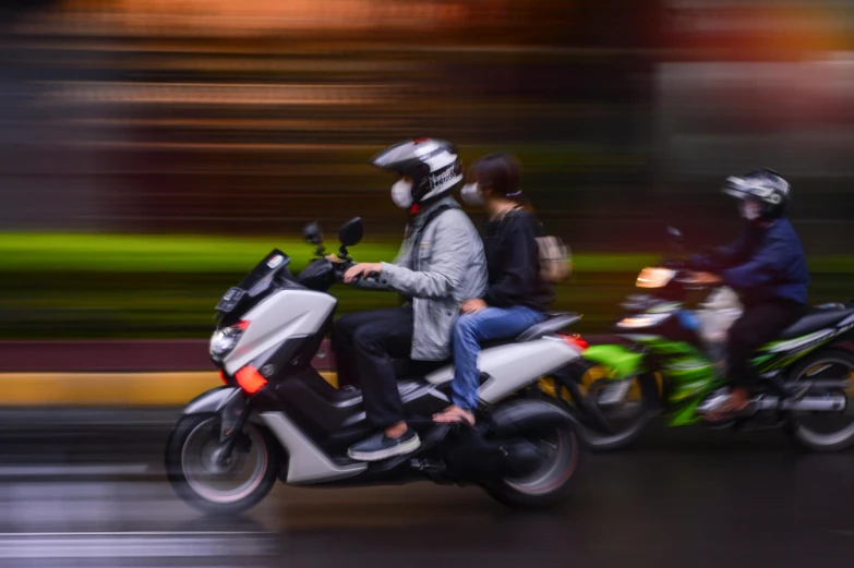 two motorcycles and one motorcyle with people on them