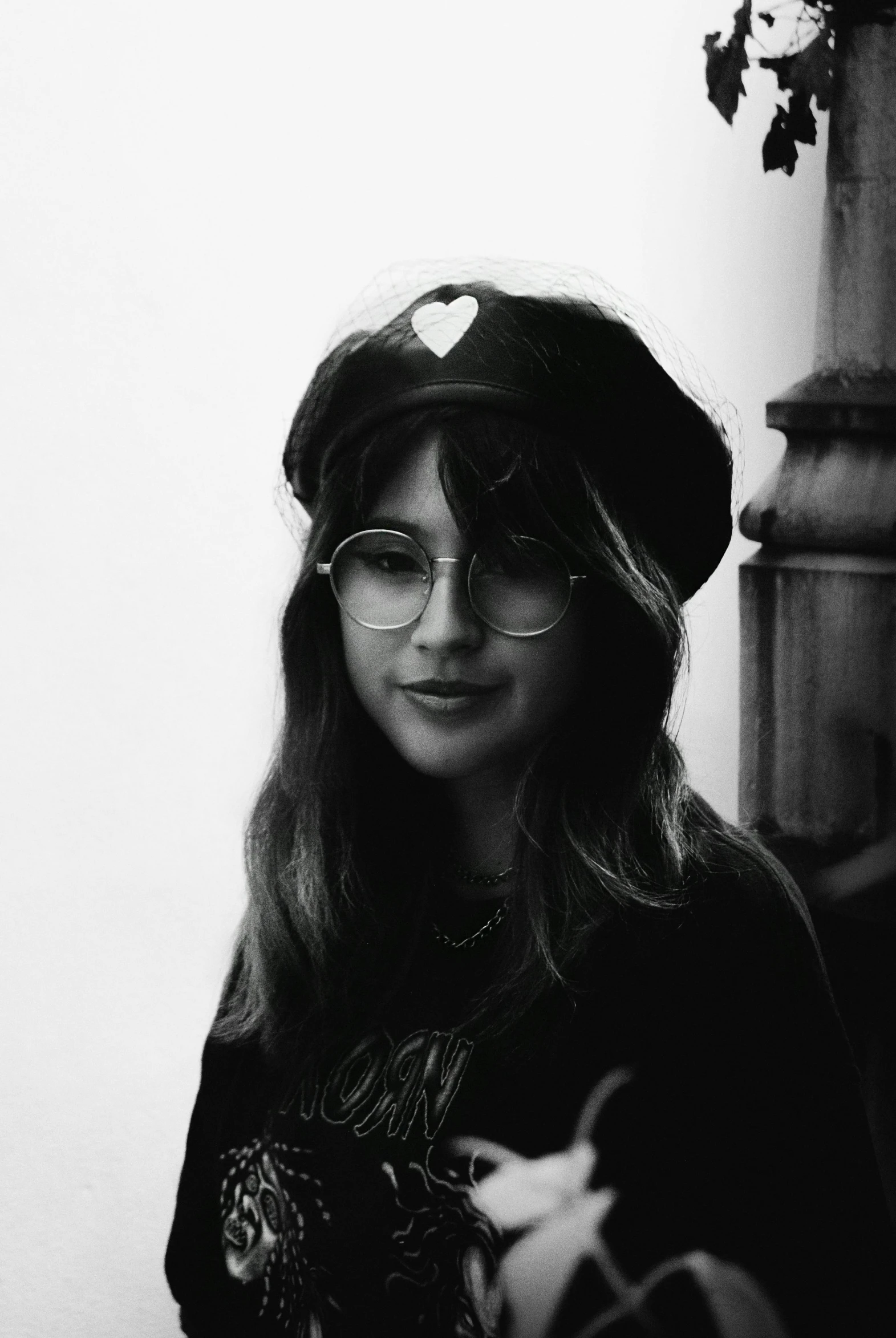 black and white image of woman wearing heart shaped glasses